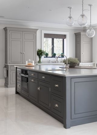 Grey kitchen by Humphrey Munson with light grey cabinets and a dark grey kitchen island