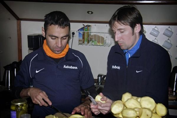 Juan Manuel Garate and Denis Menchov peel some potatoes.