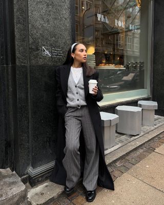 Influencer wears pinstripe trousers.