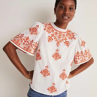 white and orange embroidered top