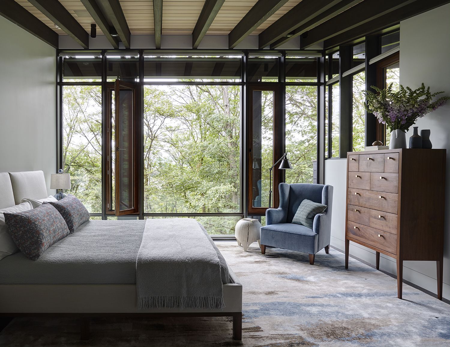 bedroom with large picture window looking out to trees