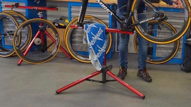 A red bike stand sits on a workshop floor