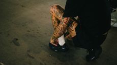 Heavily tattoed runner trying on Craft running shoes