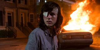 carl in front of a burning car on the walking dead