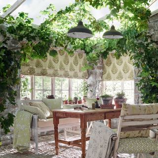 garden room/conservatory with table and chairs, fabrics, cushions, throws, foliage on ceiling and walls