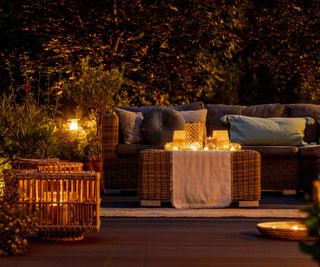 An outdoor seating area lit up at night with candles