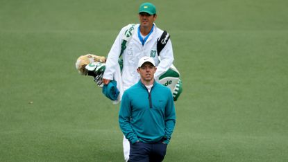 Rory McIlroy and his caddie walk at the 2022 Masters
