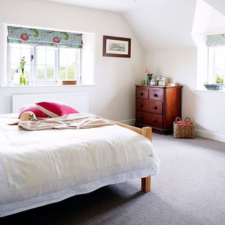 main bedroom with white bedlinen and pink cushions