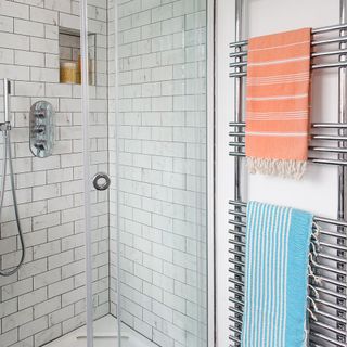 white tiled bathing area with towels