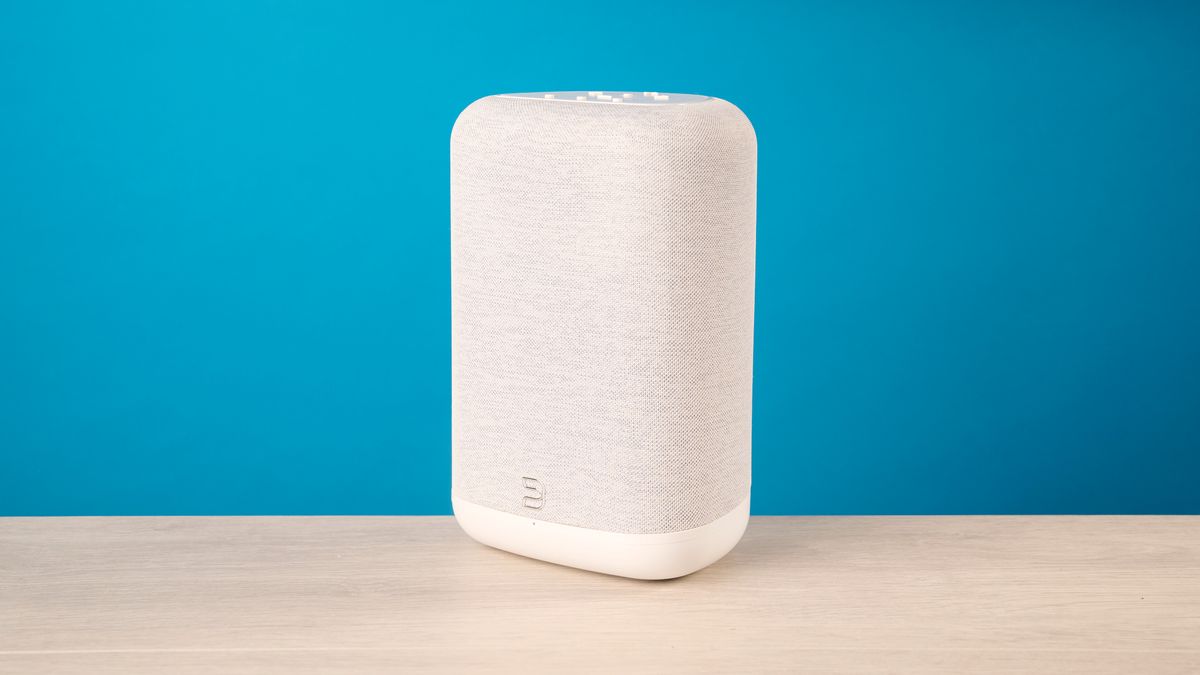 the bluesound pulse flex wi-fi speaker in pale gray photographed against the blue tom's guide background