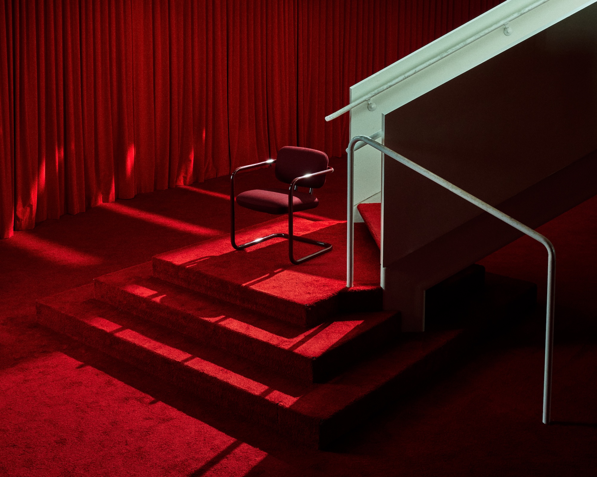 a red cantilevered chair on a red staircase