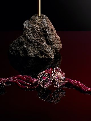 Pink toned jewelry and rock behind