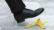 A businessperson about to step on a banana peel