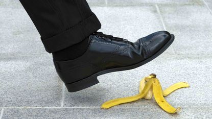 A businessperson about to step on a banana peel