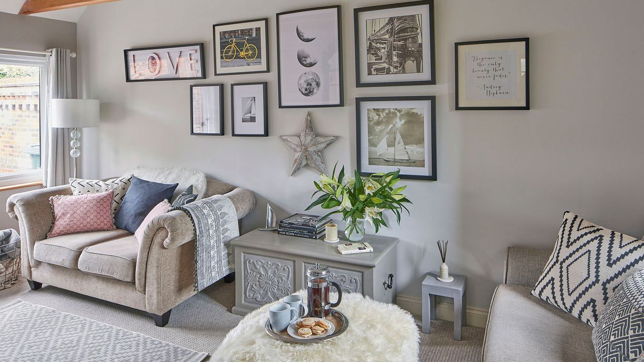 eighties house in oxfordshire exterior living room with sofa set with cushions and flower vase and photo frames on wall