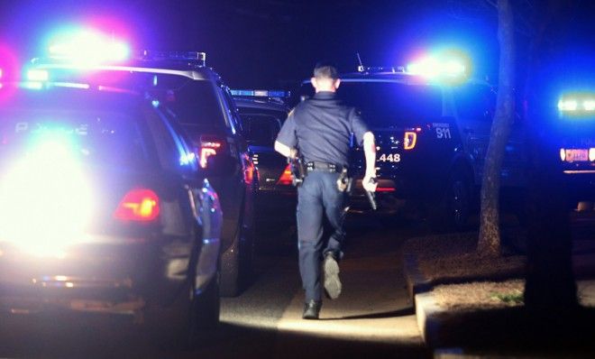 A police officer runs with his gun drawn while searching for the Boston bombing suspect on April 19.