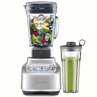 A Breville Super Q blender filled with fruit and with its personal blender attachment