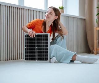 A woman sitting with an underfloor heating tile