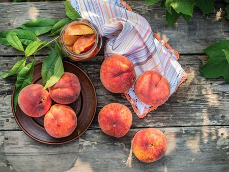 Full And Sliced Peaches On Wooden Table