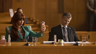 Jameela Jamil's Titania stares at her pink phone while in a court room in She-Hulk: Attorney at Law