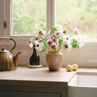 kitchen sink with old kettle and vase of flowers