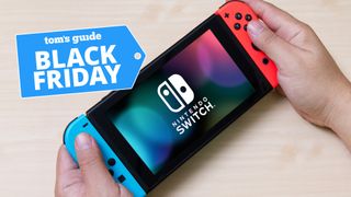 Nintendo Switch in hand with Black Friday deal tag 