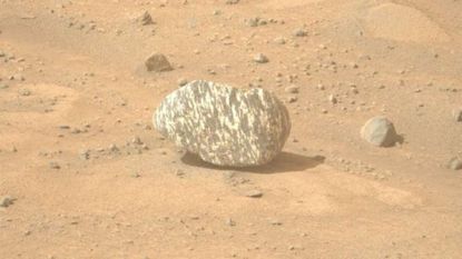Image of a striped rock captured by NASA's Perseverance rover on Mars. The rock lies on dusty, sandy ground.