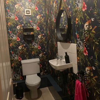 bathroom with wallpaper and commode and sink