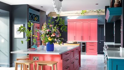 kitchen with white walls green door and wooden flooring