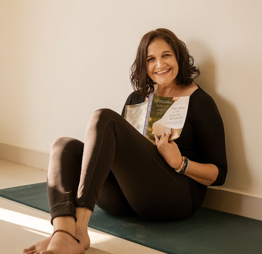 woman sits on floor leaning against a wall