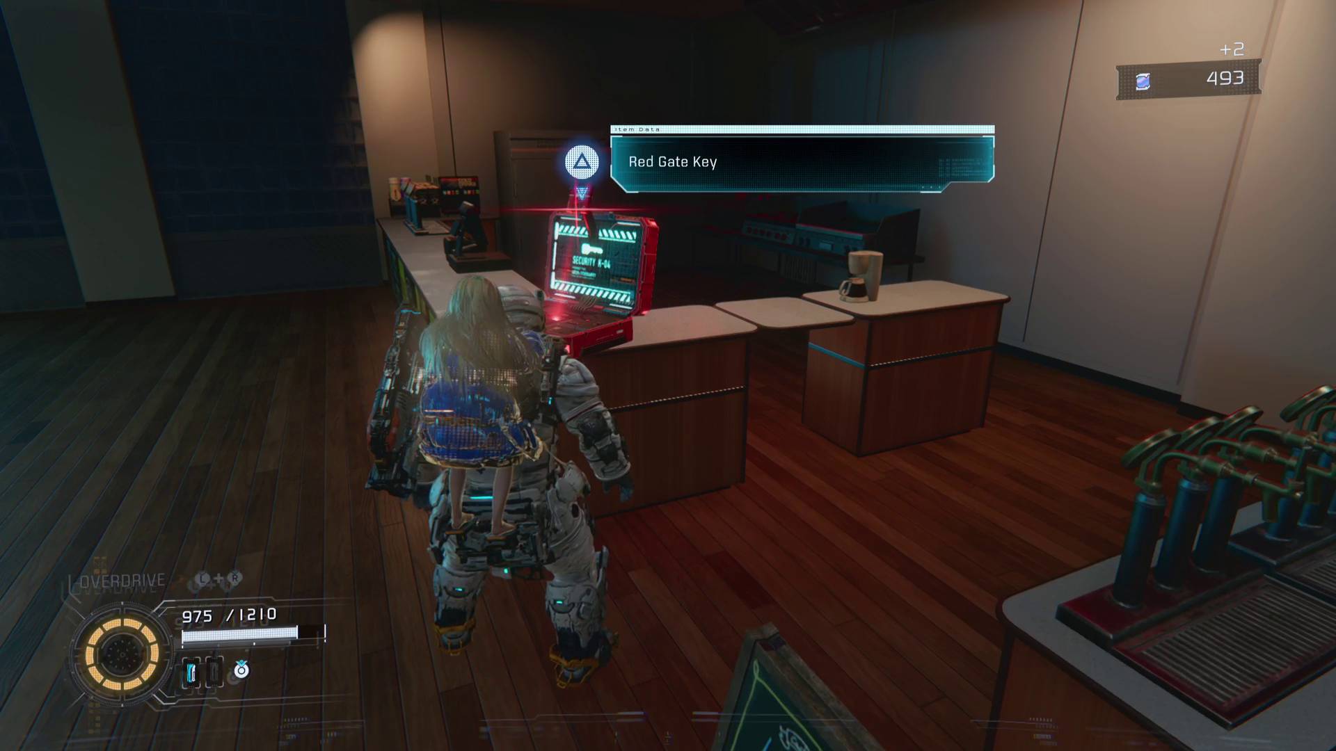 Pragmata hugh standing in front of red laptop with red gate key on top