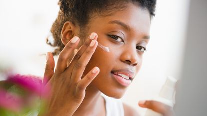 Woman putting on face cream