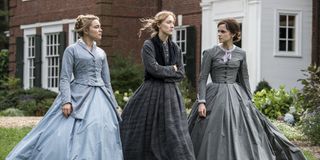 Three ladies stand together in Little Women