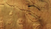 An aerial view of a reddish-orange piece of land with some valleys.