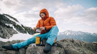 how to clean a hiking stove: hiker cleaning cooking equipment and stove