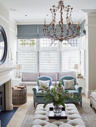 living room with blue armchairs blue ottoman and white sofa in bay window