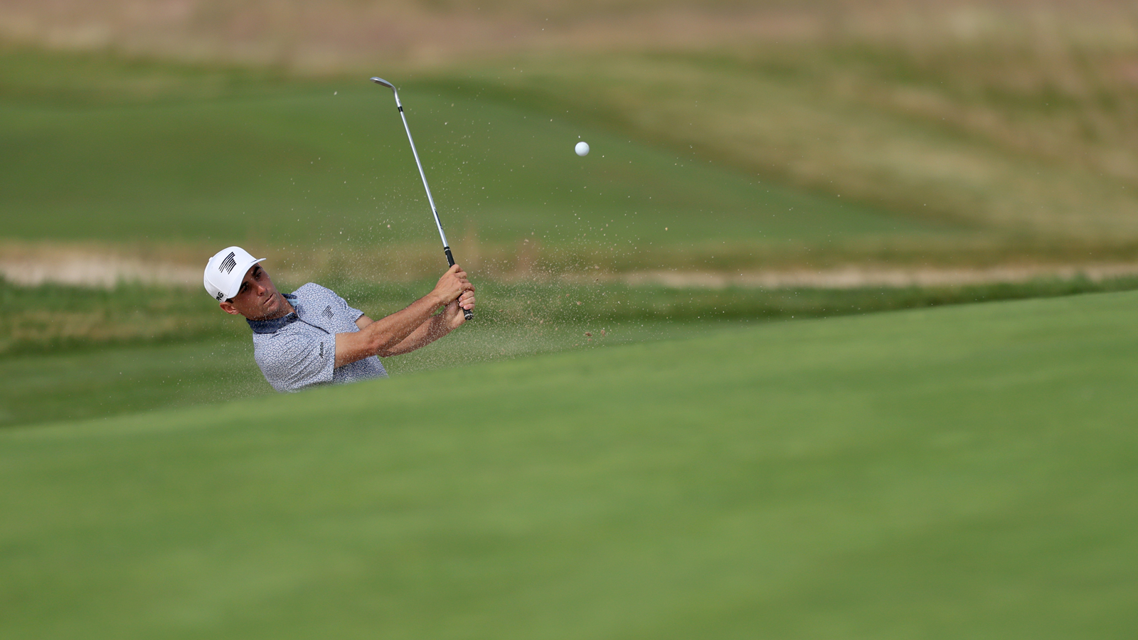 Joaquin Niemann hits a bunker shot