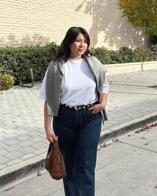 Marina Torres 6 Effortless Outfit Formulas That Are Easy to Pull Off White Tee T-Shirt Studded Belt Jeans Sweater Over the Shoulder Outfit Idea Spring Style