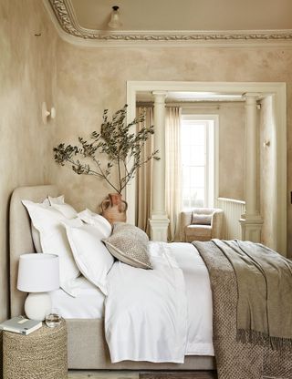 Beige bedroom with textured throw and white bedlinen