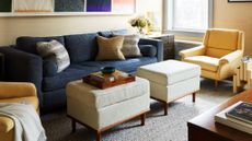 living room with yellow wallpaper and chair, and blue sofa