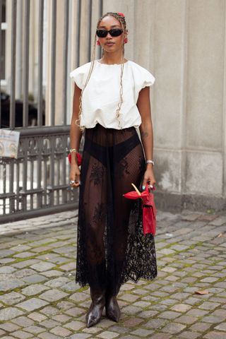 Woman wearing white t-shirt and lace sheer skirt GettyImages-2166019157