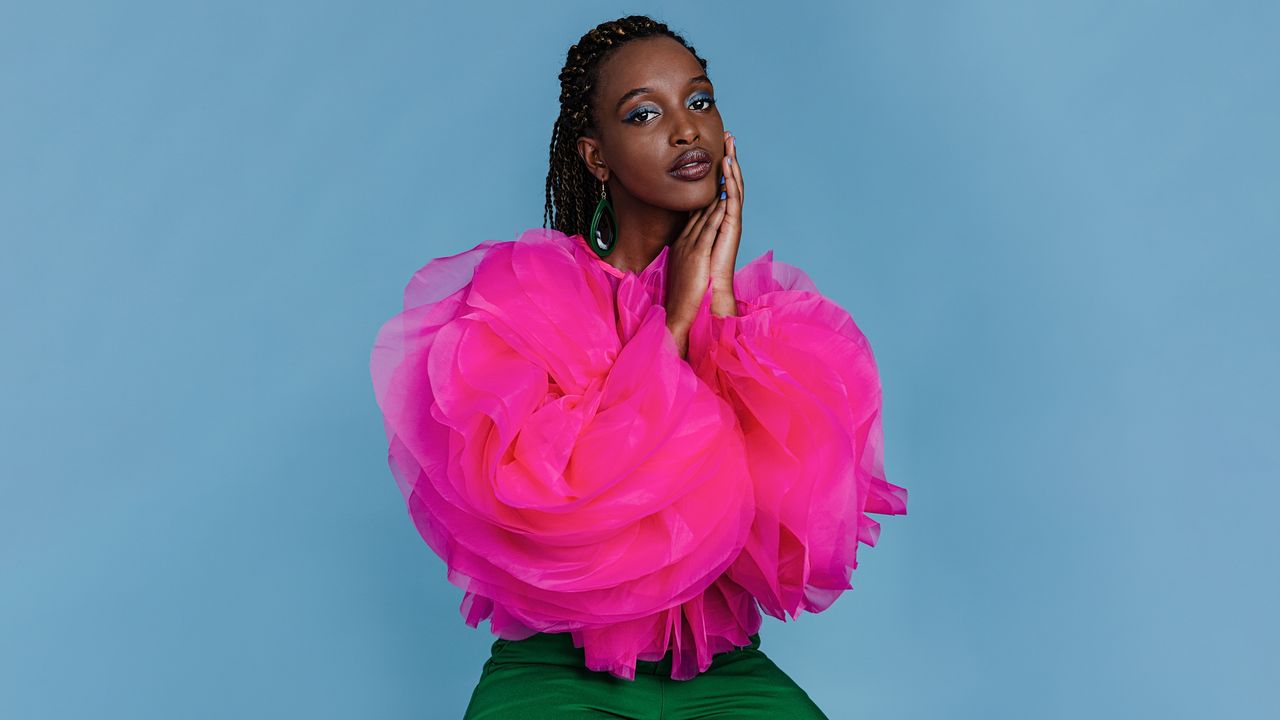 model wearing blue eyeshadow and a pink jacket