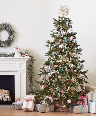 Image of a Christmas tree by a fireplace surrounded by gifts