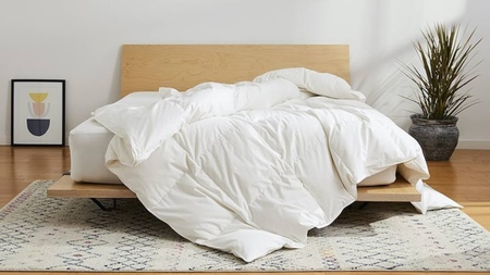 Brooklinen All-Season Down Comforter draped on the bed in a brightly lit room
