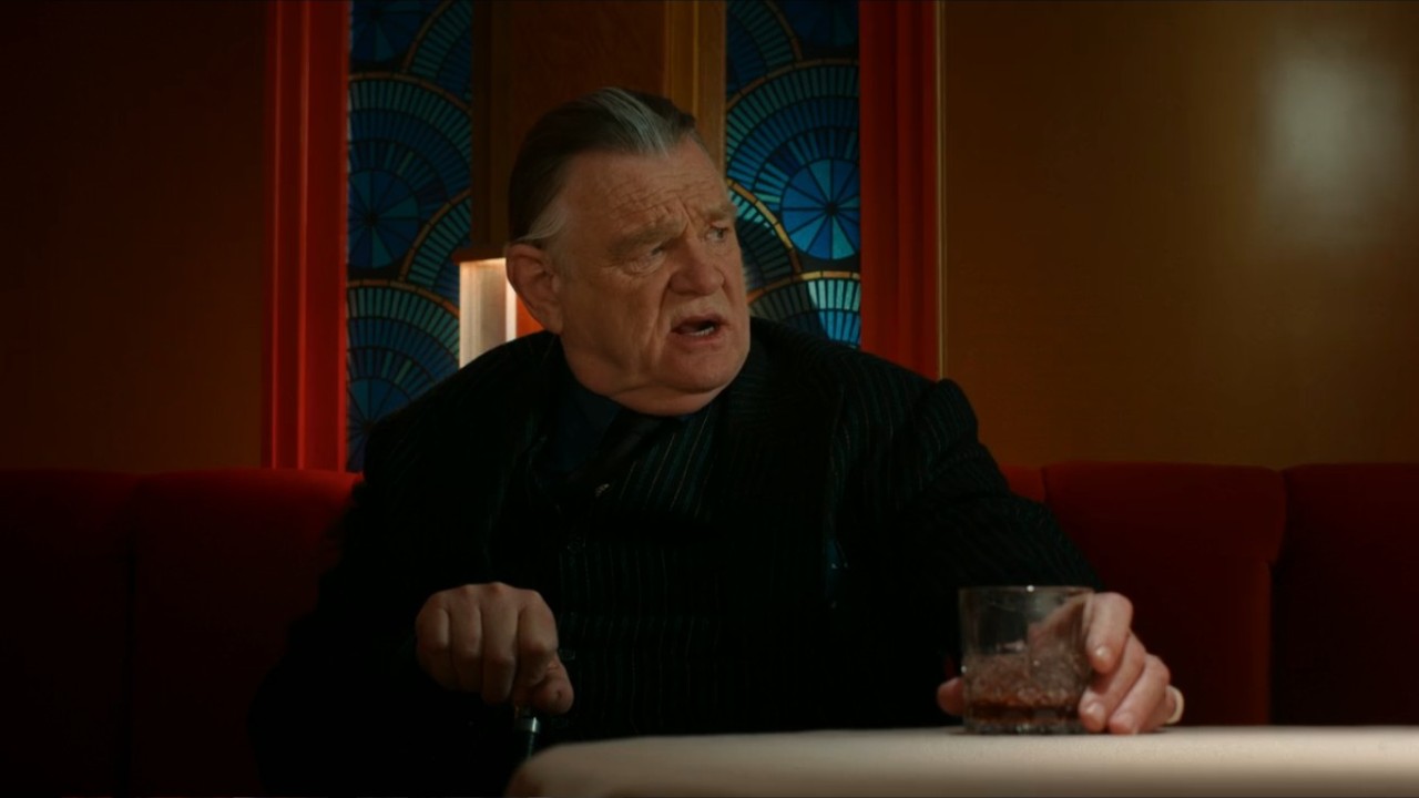 Brendan Gleeson at a table in Spider-Noir.