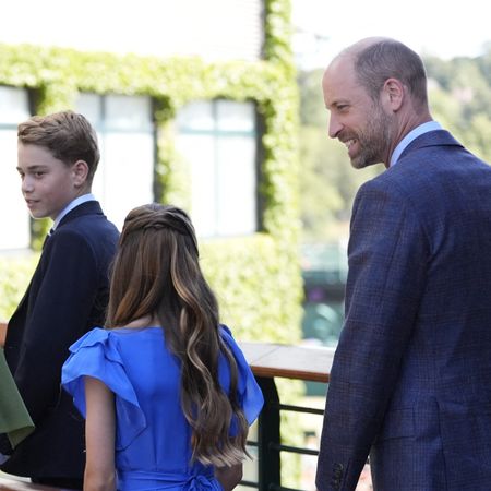 Prince George walking with Princess Charlotte and Princess Kate across a bridge