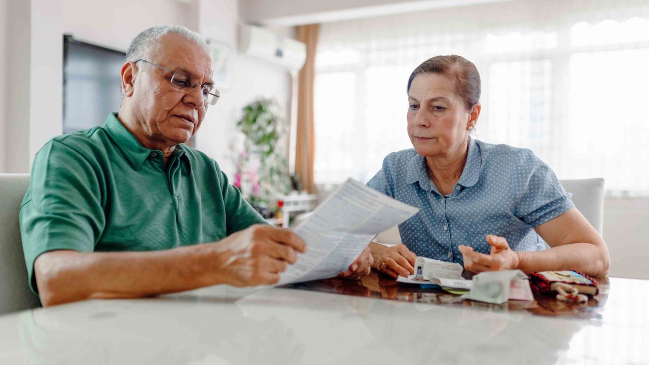 Senior couple at home with many bills