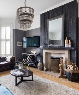 Living room with fireplace and black charred wood covering the chimney breast