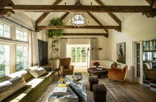 Exposed wooden beams, green sofa, blue and white marble triangle coffee tables