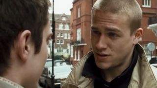 Charlie Hunnam talking to someone on a street in Green Street Hooligans